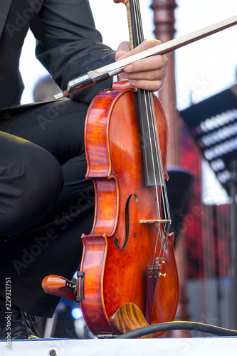 The musician holds the violin in his hands during the break on the concert_
