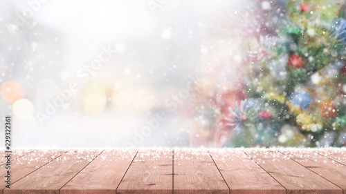 Empty wood table top on blur with bokeh Christmas tree background with snowfall - can be used for display or montage your products.