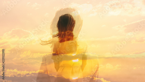 Double exposure of young woman and sunset sky.