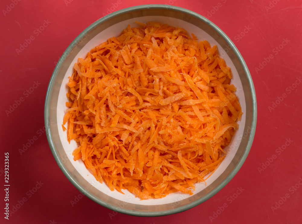 Close-up view of grated carrot is in round bowl. Close-up view of grated carrot is in round bowl.