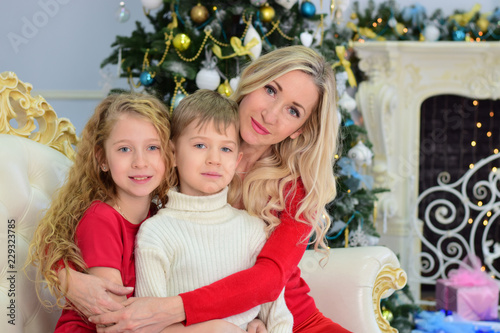 Portrait of a woman and two children with a Christmas tree