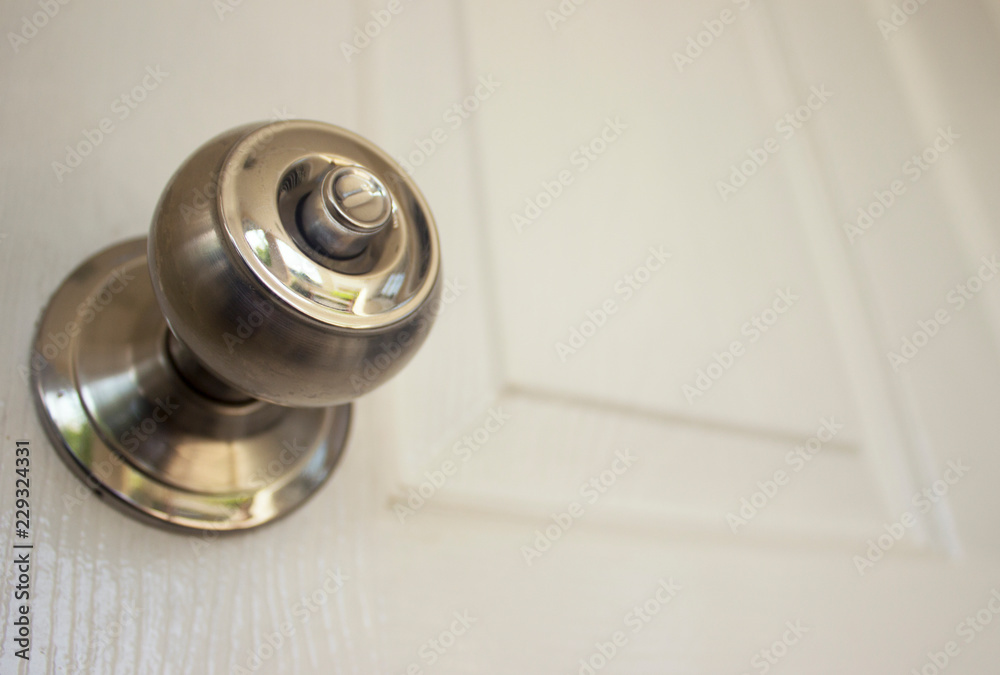 Aluminum door knob on the white wooden door Aluminum door knob on the white wooden door