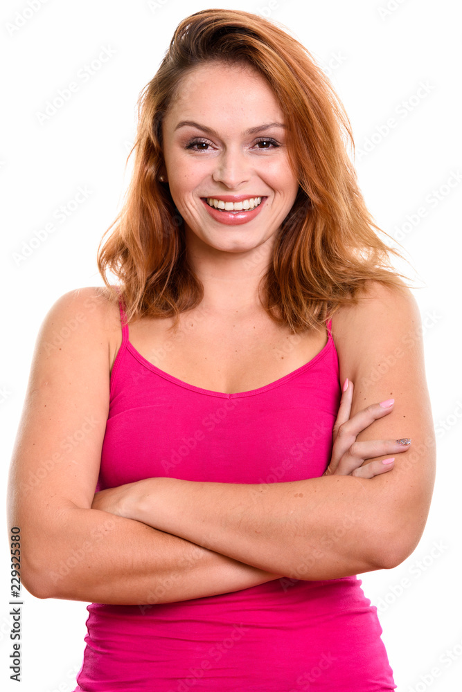 Studio shot of young happy Brazilian woman smiling with arms cro Studio shot of young happy Brazilian woman smiling with arms cro