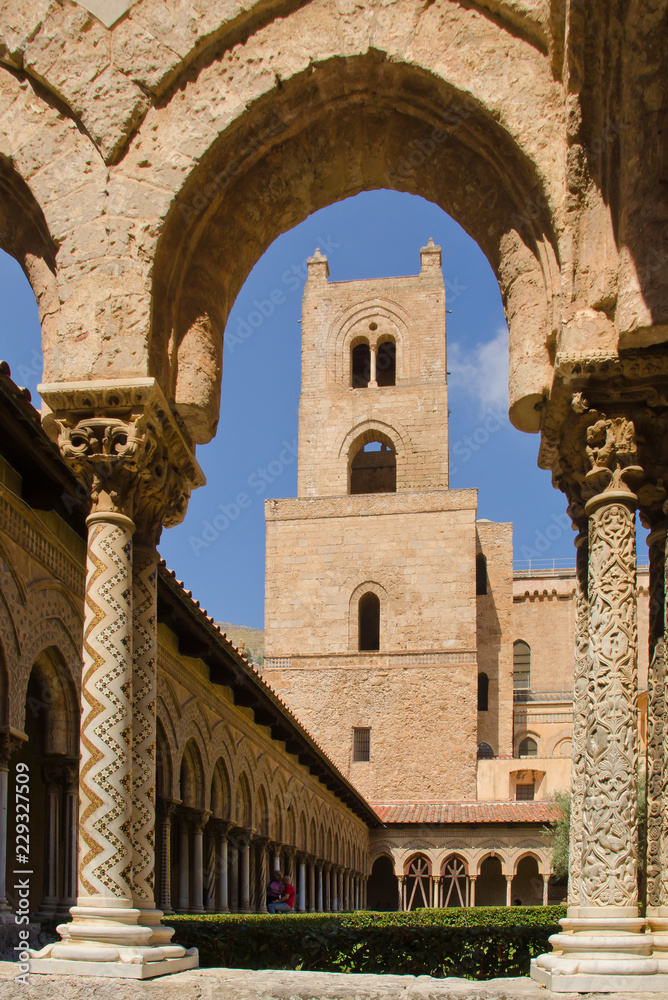 Monreale near Palermo, Sicily, cathedral. Tower and cloister, seen through an arch with columns and mosaics in the foreground