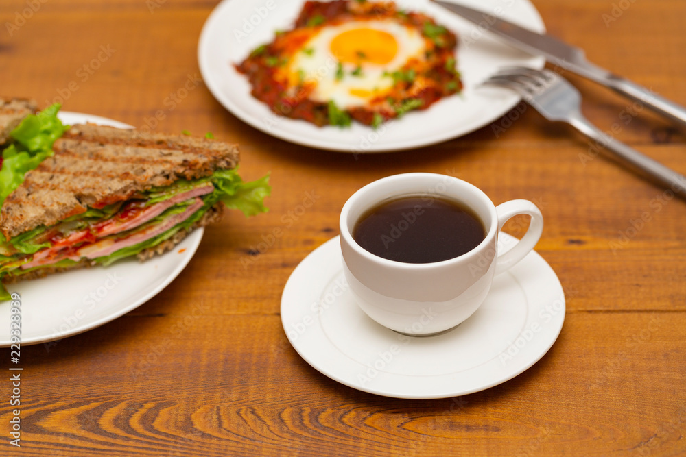 Coffee, sandwich and fried egg. Delicious breakfast