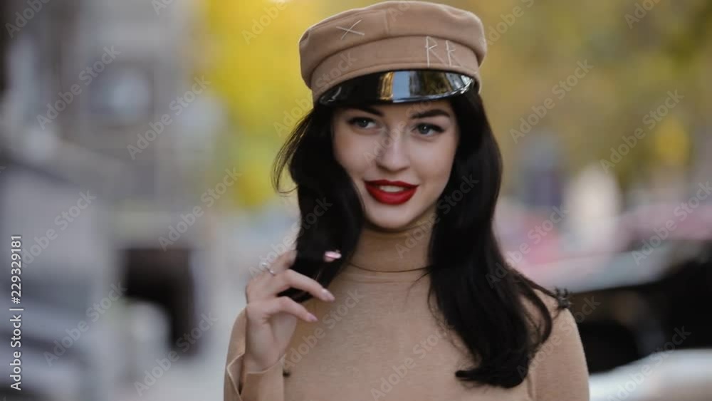 Pretty brunette woman in hat touching hair Pretty brunette woman in hat touching hair