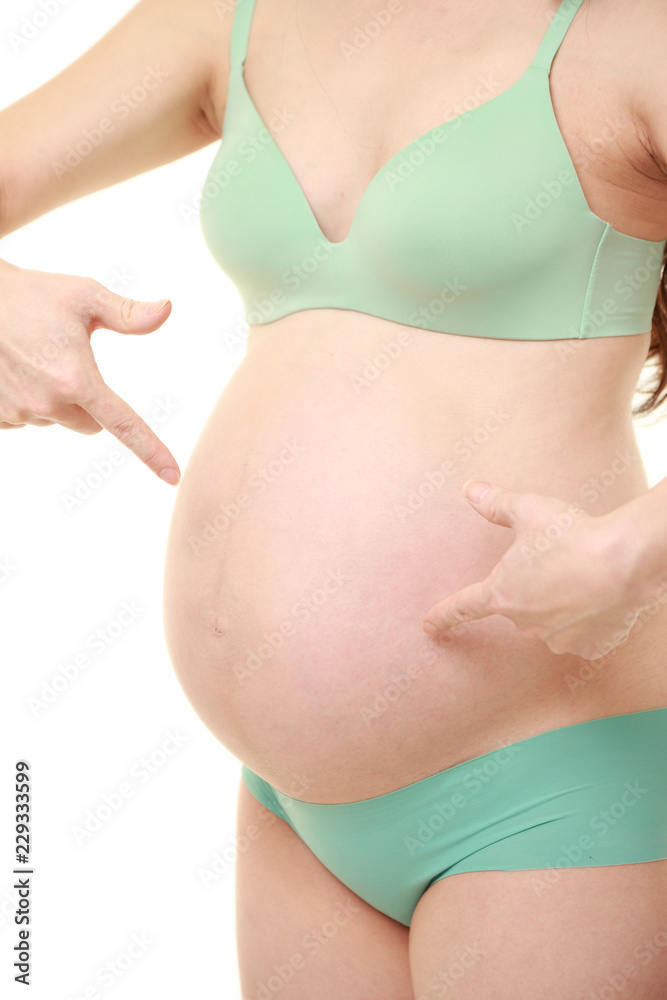 大きくなったお腹をアピールする緑色の下着を着た臨月の妊婦 Stock 写真 Adobe Stock