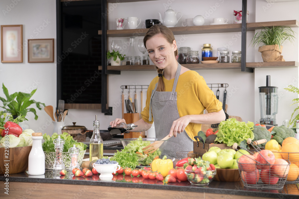Healthy young woman in a kitchen preparing fruits and vegetables for healthy meal and salad Healthy young woman in a kitchen preparing fruits and vegetables for healthy meal and salad