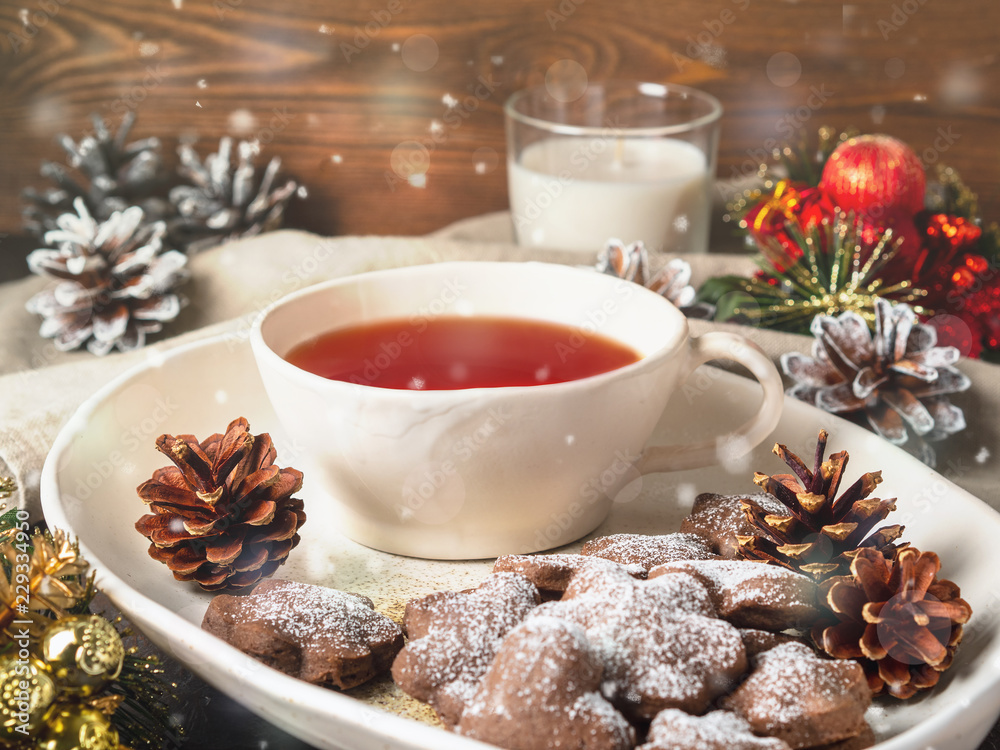 Christmas or new year card. Winter holiday composition, side view, selective focus, brown wooden background. Tea, cookie