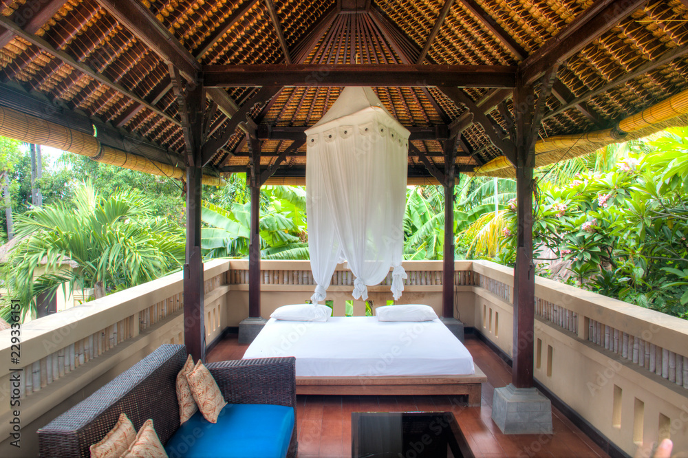 Fancy outdoor hotel room with view over the palm trees in Pemuteran in Bali, Indonesia