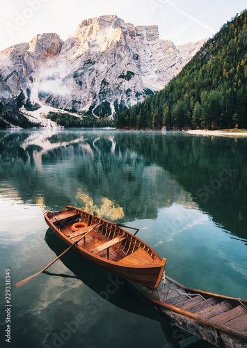 Boats and slip construction in Braies lake with crystal water in background of Seekofel mountain in Dolomites in morning, Italy Pragser Wildsee © bortnikau