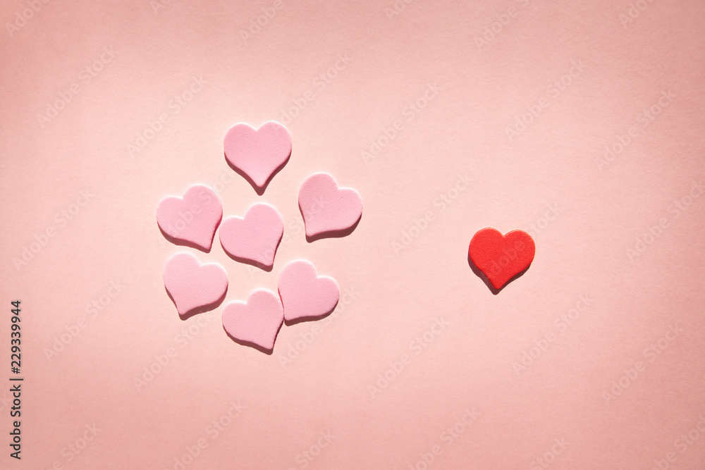 Many pink hearts versus one red, card with shapes about feelings or valentines day on pink