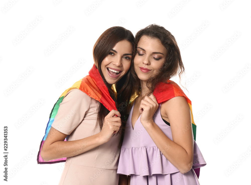 Happy young lesbian couple with rainbow flag on white background Happy young lesbian couple with rainbow flag on white background