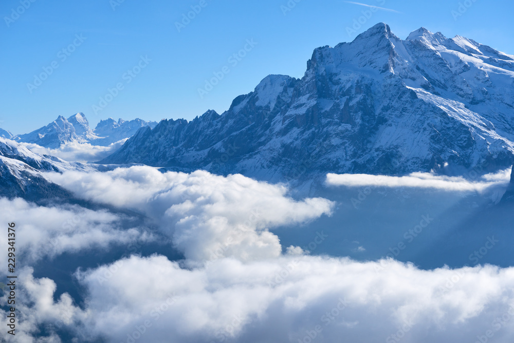 First snow and winter mountain landscape in mid october with clouds in the valley. Jungfrau region in Switzerland.