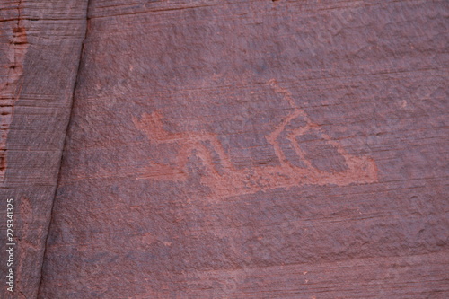 petroglyph of a navajo flute player on red rock in monumenty valley