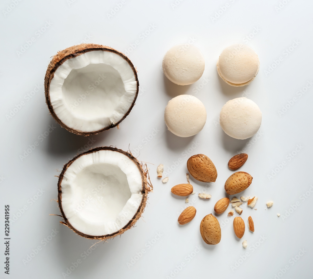 Fresh tasty macaroons with cut coconut and almonds on white background Fresh tasty macaroons with cut coconut and almonds on white background