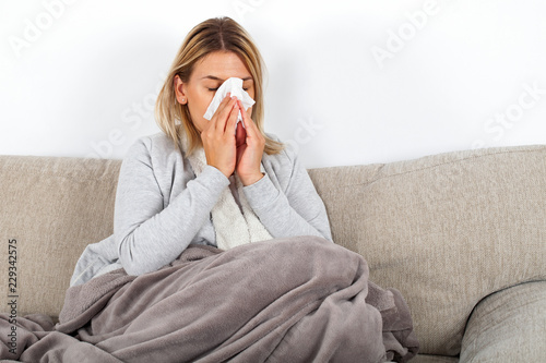 Sick woman blowing her nose