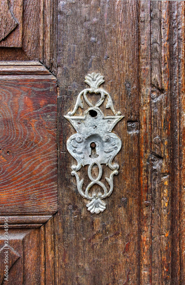 Antique keyhole on old paneled wooden door