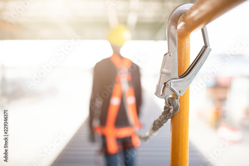 Tableau sur toile Industrial Worker with safety protective equipment loop hanging on the bar besid