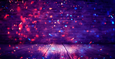 Dark basement room, empty old brick wall, sparks of fire and light on the walls and wooden floor. Dark background with smoke and bright highlights. neon lamps on the wall, night view.