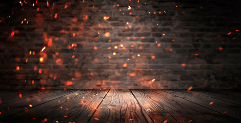 Dark basement room, empty old brick wall, sparks of fire and light on the walls and wooden floor. Dark background with smoke and bright highlights. neon lamps on the wall, night view.