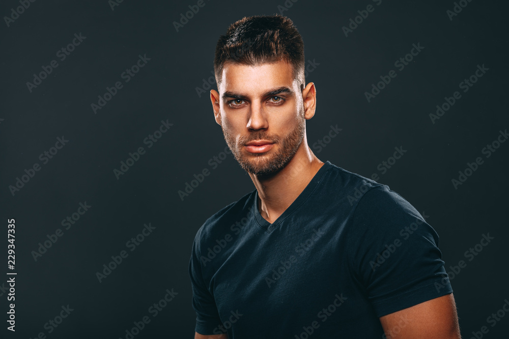 Handsome man posing in studio on dark background