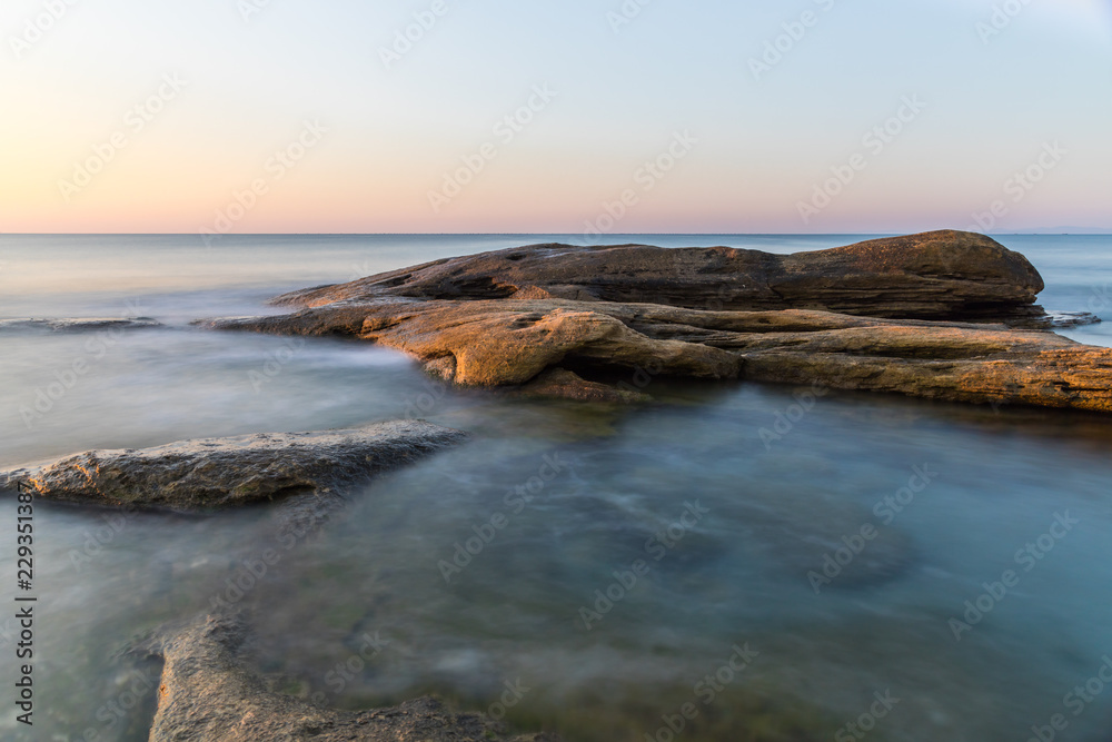 The wild sea beach with stones at sunrise. Bulgaria
