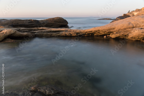 The wild sea beach with stones at sunrise. Bulgaria