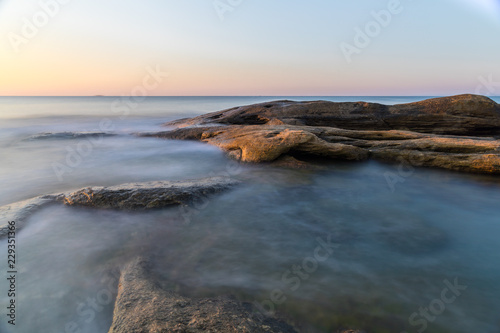 The wild sea beach with stones at sunrise. Bulgaria