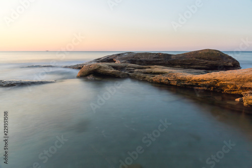 The wild sea beach with stones at sunrise. Bulgaria