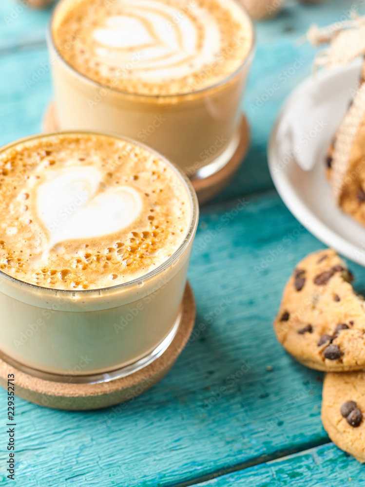 Two cappuccino coffee by delicious chocolate chip cookies.