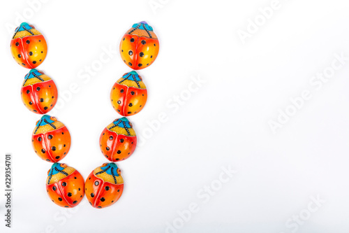 beautiful set of multicolored ladybugs forming an letter v in Mexican ceramics, top view, copy space, flat lay, space for text