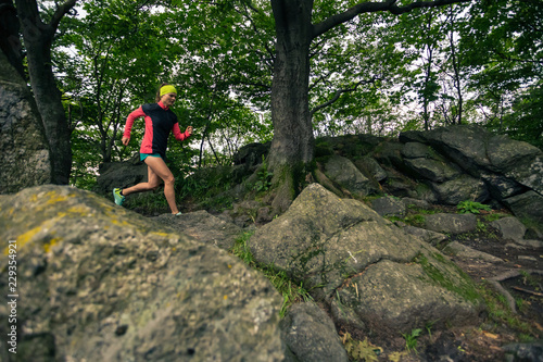 Trail running girl in green forest. Endurance sport. © blas