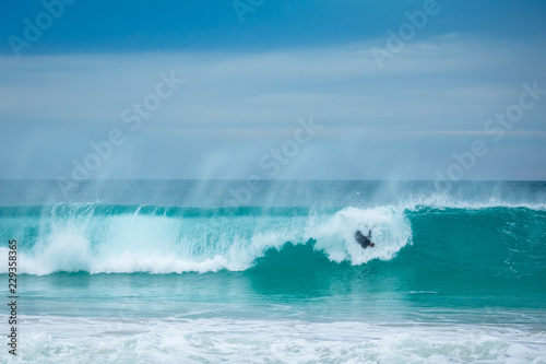 wave crashing on surfer