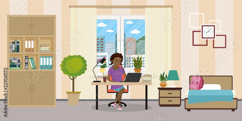 Teen room interior.African american female teen working on laptop