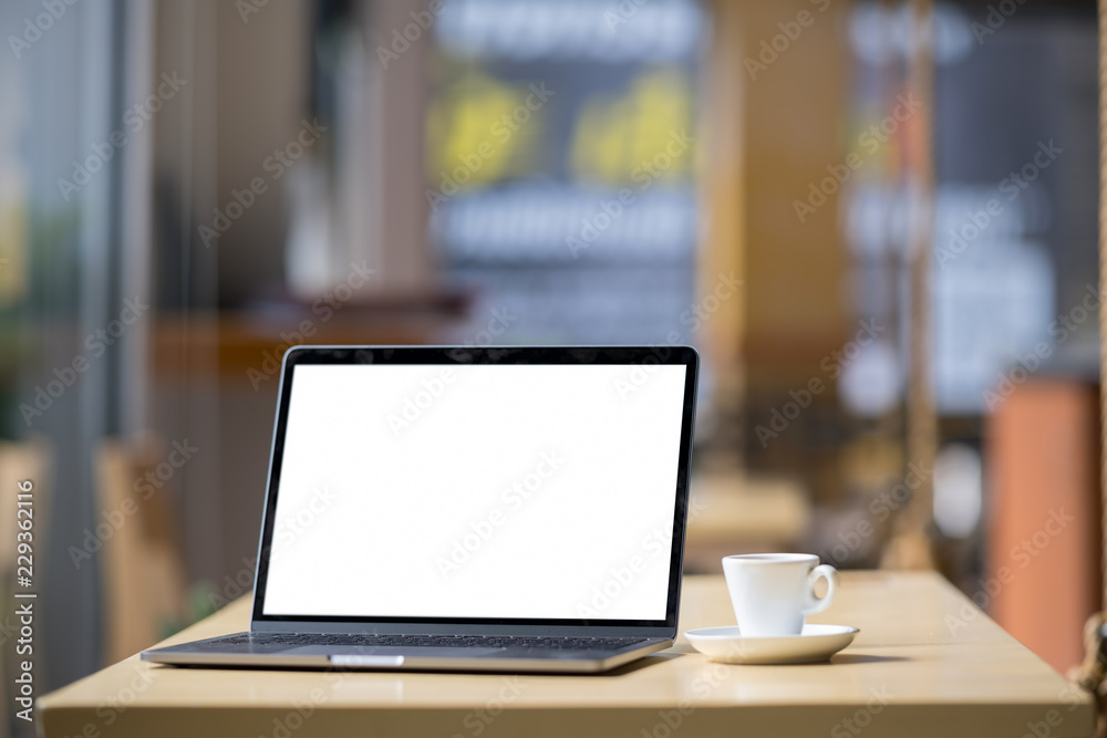 Fototapeta premium Mockup blank screen laptop on table in cafe background.