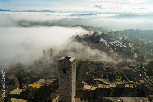 A wonderful italian landscape seen from the top of an old tower looking toward the valley where the hills get submerged by the upcoming mist