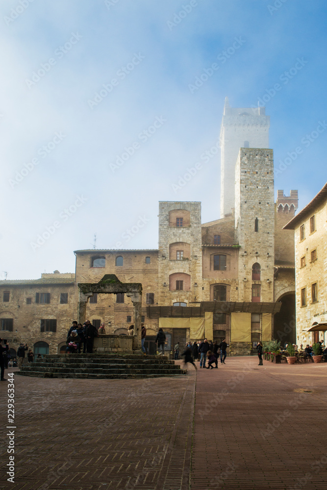 The beautiful main square of San Gimignano, a little medieval town in tuscany. In the center of this wide space there still is the old well