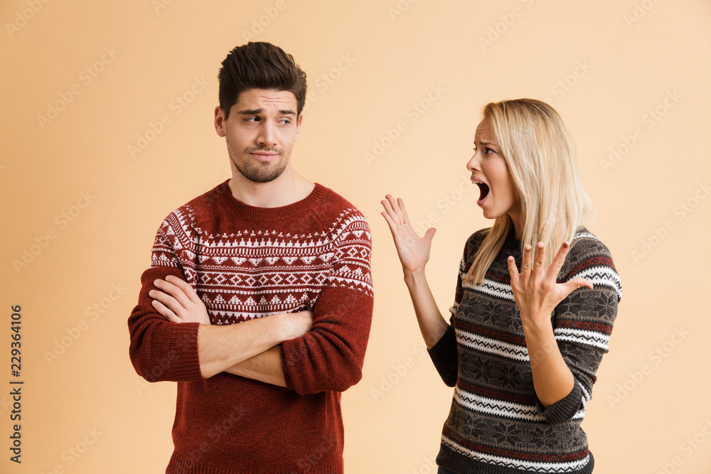 Portrait of an irritated young couple dressed in sweaters Portrait of an irritated young couple dressed in sweaters