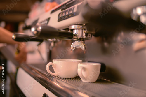 Two cups. Focused photo on modern apparatus that doing aroma coffee for guests