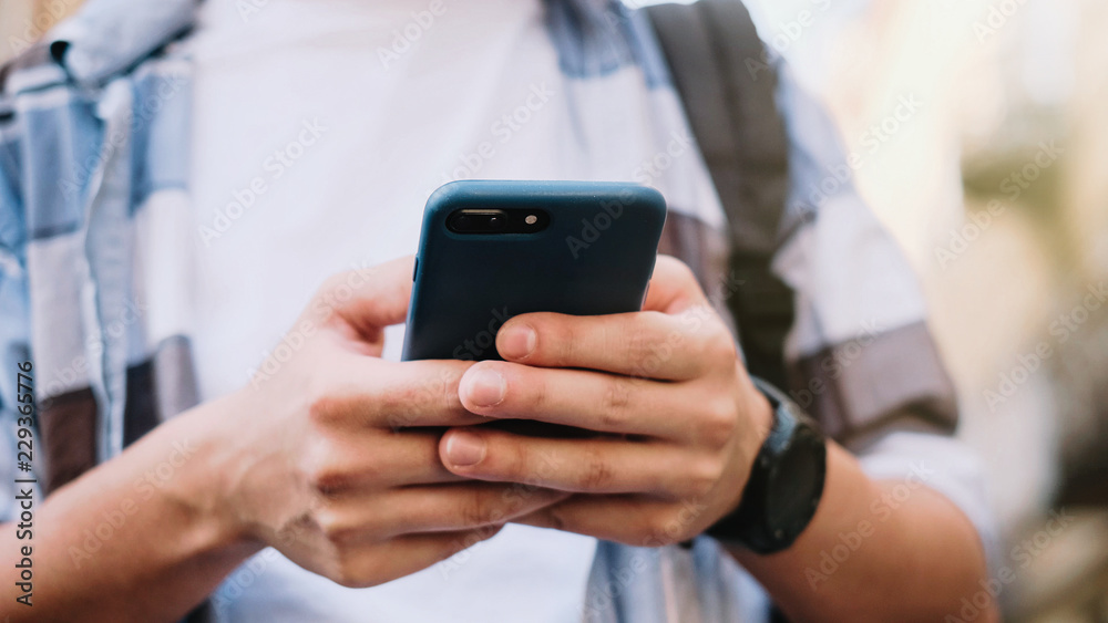 young man using his mobile phone in city. Close up of a man usin young man using his mobile phone in city. Close up of a man usin