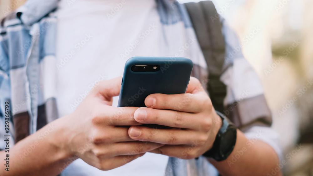 young man using his mobile phone in city. Close up of a man usin young man using his mobile phone in city. Close up of a man usin