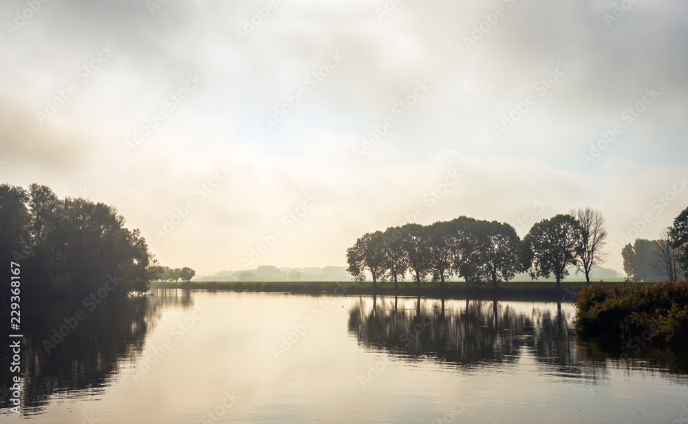 Fototapeta premium Color photo of a misty autumn morning at the lake