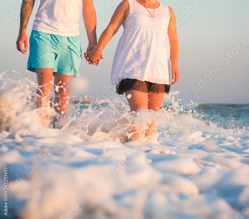 Couple standing in the foam of a wave