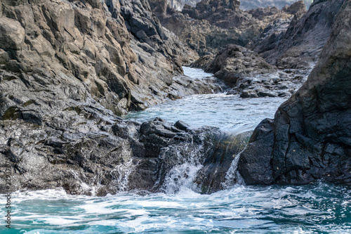 Sea water cascading over igneous volcanic rocks on La Palma, Canary Islands, Spain