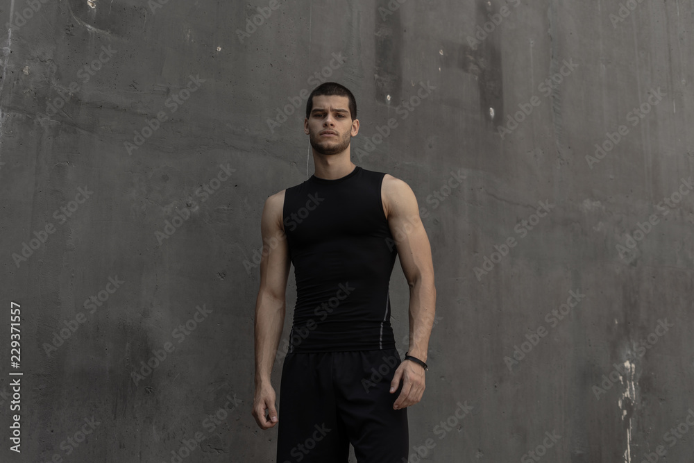Sport model man posing gray wall background Sport model man posing gray wall background