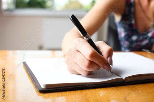 Woman writes in notebook photo