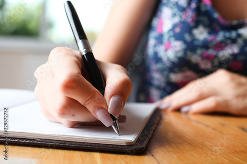 Woman writes in notebook