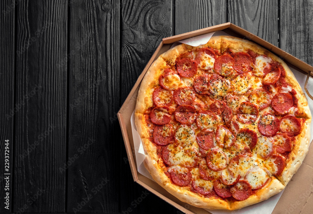 pepperoni pizza on dark black wooden board, top view, place for text, traditional italian pizza pepperoni pizza on dark black wooden board, top view, place for text, traditional italian pizza