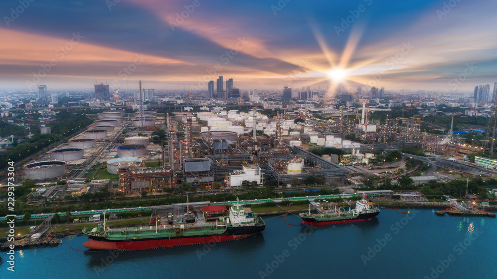 Oil refinery factory and tanker boat with beautiful sky at dusk for energy or gas industry or transportation background.